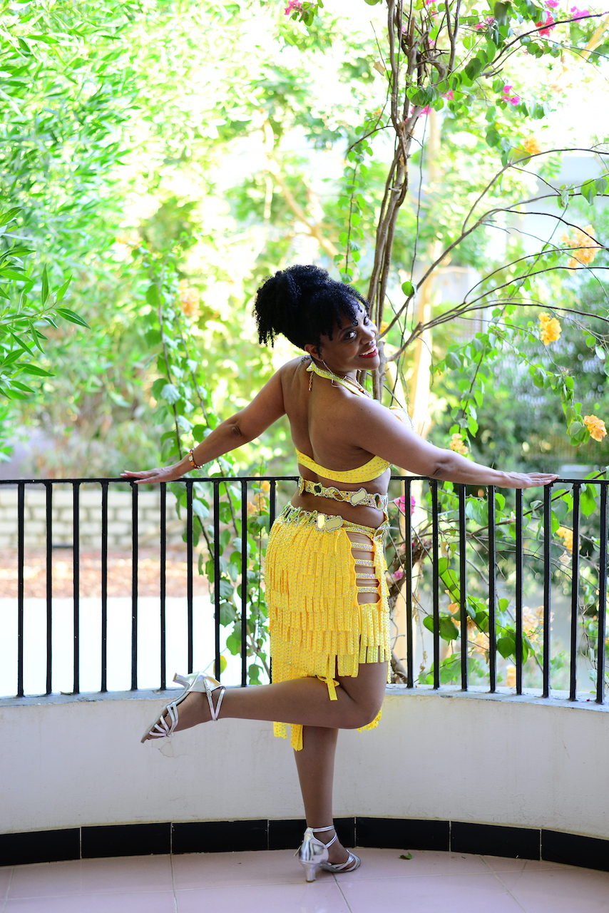 Kim Maria in yellow costume looking over shoulder