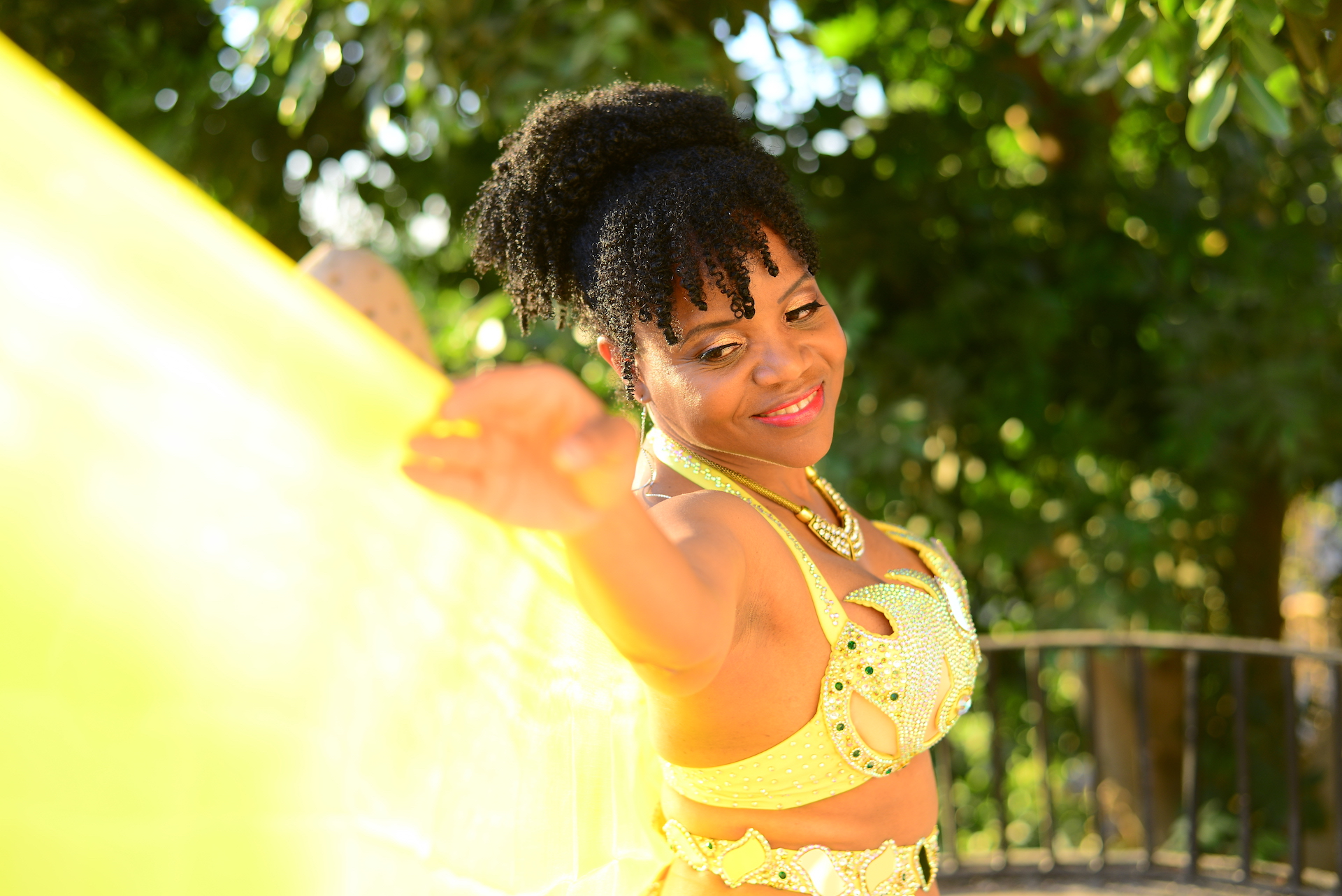 Kim Maria in sunlight looking at edge of yellow veil